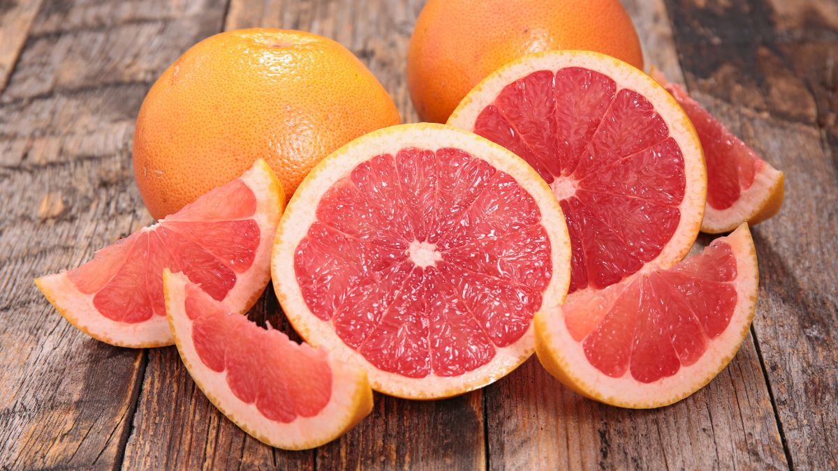 Friss grapefruitok, szeletekre vágva, fából készült asztalon.